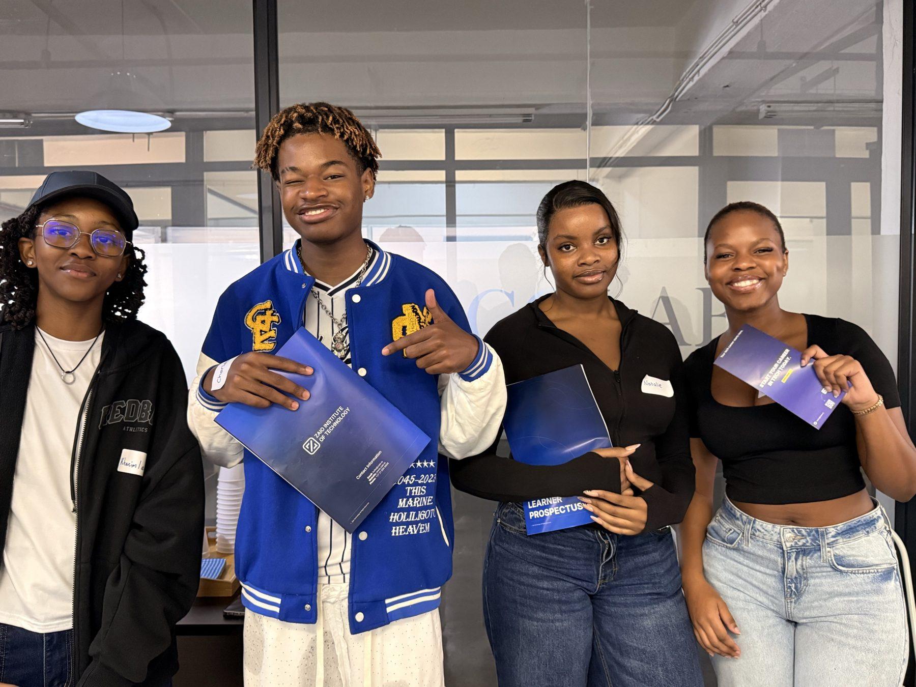 Four students holding Zaio prospectuses at the Cape Town Innovation Hub
